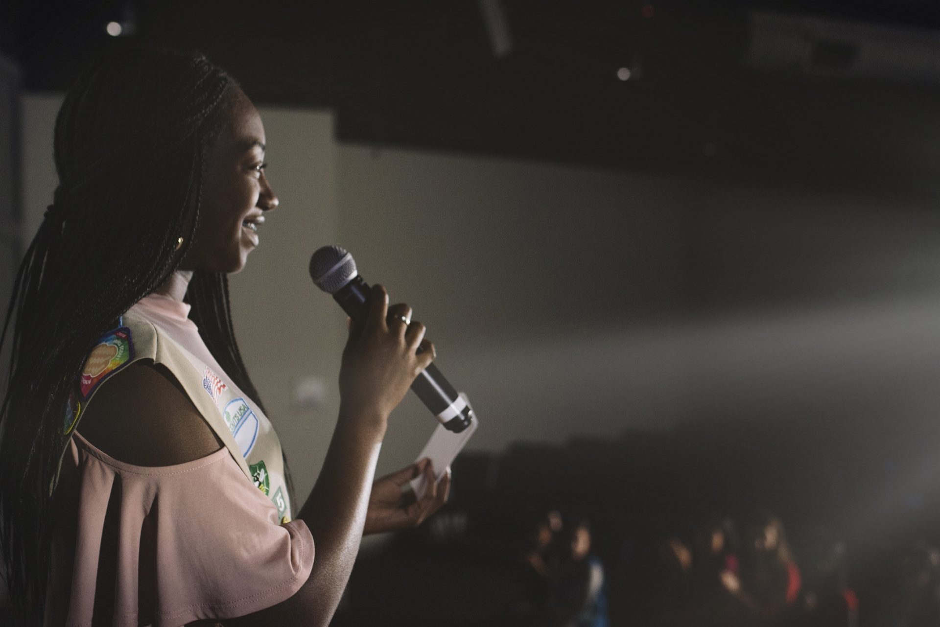 Girl Scout speaking into a microphone in front of an audience