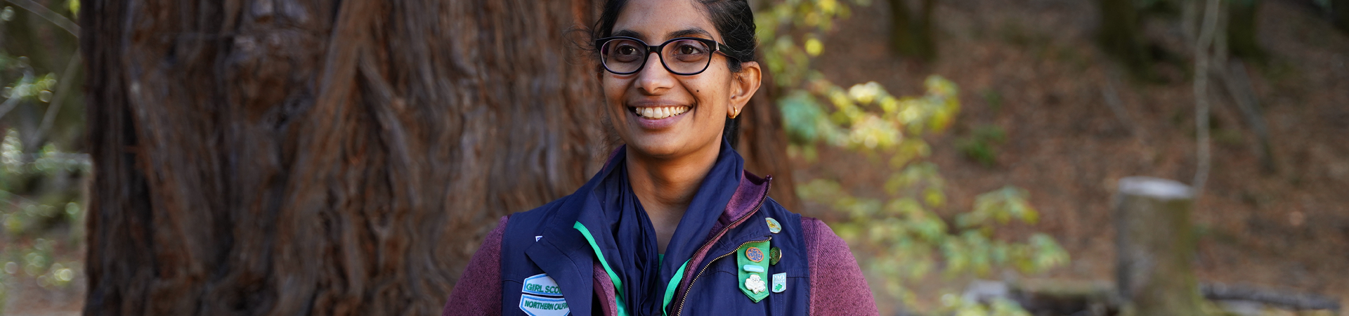  adult woman volunteer in vest outside hiking and smiling 
