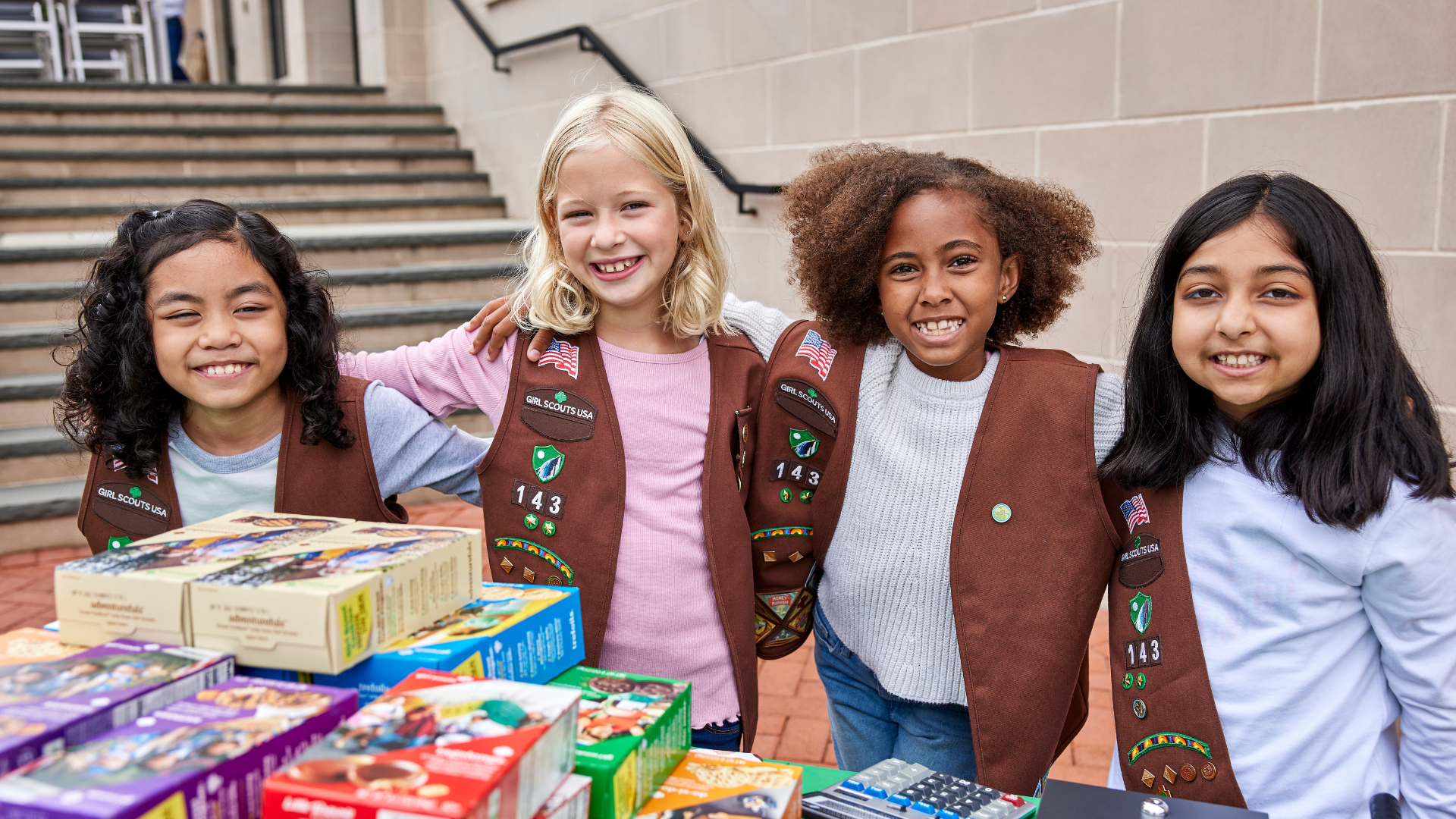 Pictured: Girl Scouts in Brownie uniforms at a Cookie Booth 