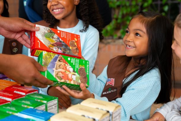 Image: A Girl Scout selling cookies.